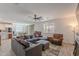 Bright and open living room features a large sectional sofa, ceiling fan, and fireplace extending to dining area at 1744 W Hopi Dr, Coolidge, AZ 85128