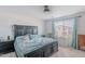 Spacious main bedroom with a large bed, ceiling fan, and window with soft blue curtains and blinds at 1744 W Hopi Dr, Coolidge, AZ 85128
