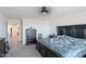Main bedroom featuring a large bed with a blue patterned comforter, dark furniture, and neutral carpet at 1744 W Hopi Dr, Coolidge, AZ 85128