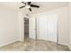 Bright bedroom boasts ceiling fan and closet with modern light fixture and travertine floor at 1831 N 77Th St, Scottsdale, AZ 85257