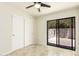 Bright bedroom features a ceiling fan, travertine floor and sliding door to the outside patio at 1831 N 77Th St, Scottsdale, AZ 85257