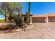 Desert landscaped home with a brown tile roof, stucco walls, and a two car garage at 1831 N 77Th St, Scottsdale, AZ 85257