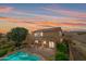 Enjoy outdoor living with a covered patio, pool, desert landscaping, and a two-story home at sunset at 18375 E San Ignacio Ct, Gold Canyon, AZ 85118