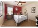 This bedroom offers a red accent wall, ceiling fan, walk-in closet and comfortable bed at 18375 E San Ignacio Ct, Gold Canyon, AZ 85118