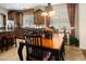 Bright dining area with a wooden table, upholstered chairs, and decorative lighting fixtures near kitchen at 18375 E San Ignacio Ct, Gold Canyon, AZ 85118