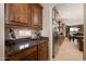 View of a kitchen area leading to a dining space, featuring wood cabinets and granite countertops at 18375 E San Ignacio Ct, Gold Canyon, AZ 85118