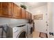 Functional laundry room featuring front loading washer and dryer, ample storage cabinets and tile flooring at 18375 E San Ignacio Ct, Gold Canyon, AZ 85118