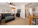 Comfortable living room offers a black leather sofa, ceiling fan, and carpet flooring at 18375 E San Ignacio Ct, Gold Canyon, AZ 85118
