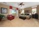 Spacious main bedroom with a king-size bed, ceiling fan, and a cozy red armchair at 18375 E San Ignacio Ct, Gold Canyon, AZ 85118