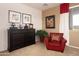 Comfortable sitting area featuring a cozy red armchair, dark dresser and decor at 18375 E San Ignacio Ct, Gold Canyon, AZ 85118