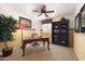 This office features a ceiling fan, an elegant wooden desk, chair and a bookshelf at 18375 E San Ignacio Ct, Gold Canyon, AZ 85118