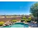 Private backyard pool and patio area with rock waterfall feature and lush desert landscaping at 18375 E San Ignacio Ct, Gold Canyon, AZ 85118