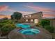 This spacious backyard offers a beautiful pool and spa, patio, lush landscaping, and a large two-story home at 18375 E San Ignacio Ct, Gold Canyon, AZ 85118