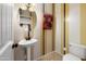 Stylish powder room with decorative striped walls, pedestal sink and features a toilet at 18375 E San Ignacio Ct, Gold Canyon, AZ 85118