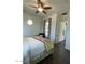 Bedroom with hardwood floors, round window, ceiling fan, and view to ensuite bathroom at 20502 W Ridge Rd, Buckeye, AZ 85396
