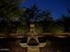 Outdoor water feature surrounded by lush landscaping and subtle landscape lighting at 20502 W Ridge Rd, Buckeye, AZ 85396