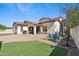 Spacious backyard with lush artificial turf, covered patio, and plenty of seating options at 20518 W White Rock Rd, Buckeye, AZ 85396