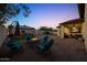 Inviting backyard at dusk with stone fire pit and outdoor seating area at 20518 W White Rock Rd, Buckeye, AZ 85396