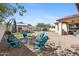 Inviting backyard with stone fire pit, turquoise Adirondack chairs, and outdoor living space at 20518 W White Rock Rd, Buckeye, AZ 85396