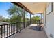 Relaxing balcony space featuring a black metal railing with a table and chairs overlooking lush green trees at 20518 W White Rock Rd, Buckeye, AZ 85396