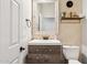 Stylish powder room featuring a decorative mirror and geometric wallpaper at 20518 W White Rock Rd, Buckeye, AZ 85396