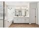 Bright bathroom featuring double sinks, a glass-enclosed shower, and a soaking tub with designer fixtures at 20518 W White Rock Rd, Buckeye, AZ 85396