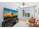 Bright bedroom featuring a TV, fan, and white shutters for ample natural light at 20518 W White Rock Rd, Buckeye, AZ 85396