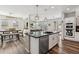 Open-concept kitchen with island, stainless steel appliances, hardwood floors, and views of the dining and living areas at 20518 W White Rock Rd, Buckeye, AZ 85396