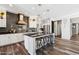 Modern kitchen with dark backsplash, white cabinets, stainless steel appliances, and a large island with seating at 20518 W White Rock Rd, Buckeye, AZ 85396