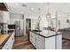 Bright kitchen featuring a large island, stainless steel appliances, dark countertops and hardwood flooring at 20518 W White Rock Rd, Buckeye, AZ 85396