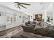 Living room has an open floor plan to the kitchen with dark wood floors and a ceiling fan at 20518 W White Rock Rd, Buckeye, AZ 85396