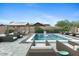 A luxurious backyard pool area with ample seating, a covered pergola, and a serene waterfall feature at 20518 W White Rock Rd, Buckeye, AZ 85396