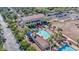 Aerial view of a luxurious community pool area with palm trees, lounge chairs, and a clubhouse at 20518 W White Rock Rd, Buckeye, AZ 85396