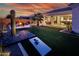 Expansive backyard with an outdoor kitchen, fire pit, and artificial turf at 22837 E Orchard Ln, Queen Creek, AZ 85142