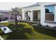 Expansive backyard featuring artificial turf, a built-in kitchen, and a tropical palm tree at 22837 E Orchard Ln, Queen Creek, AZ 85142