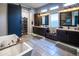 Spacious bathroom featuring double vanities, a soaking tub, a walk-in shower, and a modern barn door entrance at 22837 E Orchard Ln, Queen Creek, AZ 85142