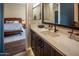 Modern bathroom with dark wood cabinets, quartz countertops, and a view into the primary bedroom at 22837 E Orchard Ln, Queen Creek, AZ 85142