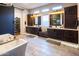 Luxurious bathroom with a freestanding tub, dual vanities, and a convenient access to a walk-in closet at 22837 E Orchard Ln, Queen Creek, AZ 85142