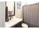 Modern bathroom with a gray shower curtain, quartz countertop, and black fixtures at 22837 E Orchard Ln, Queen Creek, AZ 85142