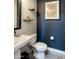 Modern bathroom featuring a white pedestal sink, toilet, and stylish decor at 22837 E Orchard Ln, Queen Creek, AZ 85142