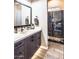 Modern bathroom with a sleek vanity, a walk-in shower with dark tile, and a clear glass enclosure at 22837 E Orchard Ln, Queen Creek, AZ 85142