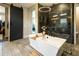 Luxurious bathroom featuring a modern tub, sliding barn door, and a walk-in shower with decorative tile accents at 22837 E Orchard Ln, Queen Creek, AZ 85142