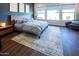 Stylish bedroom with a wood accent wall, modern furnishings, and large windows for natural light at 22837 E Orchard Ln, Queen Creek, AZ 85142