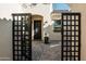 Beautiful courtyard featuring a black metal entry gate, desert landscaping, and paved flooring at 22837 E Orchard Ln, Queen Creek, AZ 85142