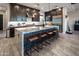 A large kitchen features dark wood cabinets, stainless steel appliances, and a central island with granite countertop and seating at 22837 E Orchard Ln, Queen Creek, AZ 85142