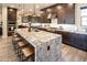 Open kitchen with large island, granite countertops, dark wood cabinetry, and stainless steel range hood at 22837 E Orchard Ln, Queen Creek, AZ 85142