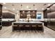 A spacious kitchen featuring dark cabinets, stainless steel appliances, granite countertops, and a large island with bar seating at 22837 E Orchard Ln, Queen Creek, AZ 85142