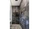Elegant walk-in shower featuring dark gray tiles, a niche, and a pebble floor, offering a spa-like experience at 22837 E Orchard Ln, Queen Creek, AZ 85142