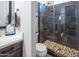 Stylish bathroom featuring a walk-in shower with gray tiles, a pebble floor, and updated fixtures at 22837 E Orchard Ln, Queen Creek, AZ 85142