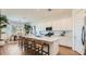 Open-concept kitchen with seating, stainless steel appliances, and white cabinetry at 23256 W Tamarisk Ave, Buckeye, AZ 85326